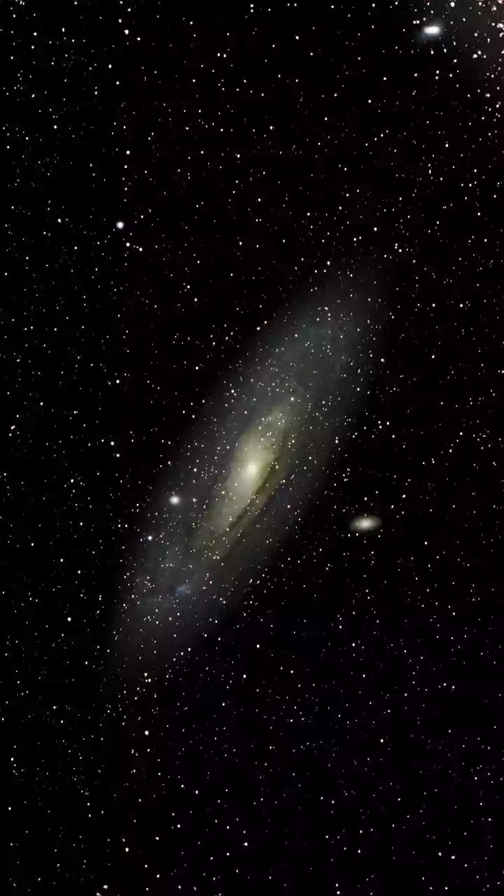 Why the Andromeda galaxy appears as a glowing spiral disk through basic binoculars in autumn skies