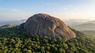 Discovering Savandurga's challenging rock climb and panoramic forest views on a weekend trek from Bengaluru